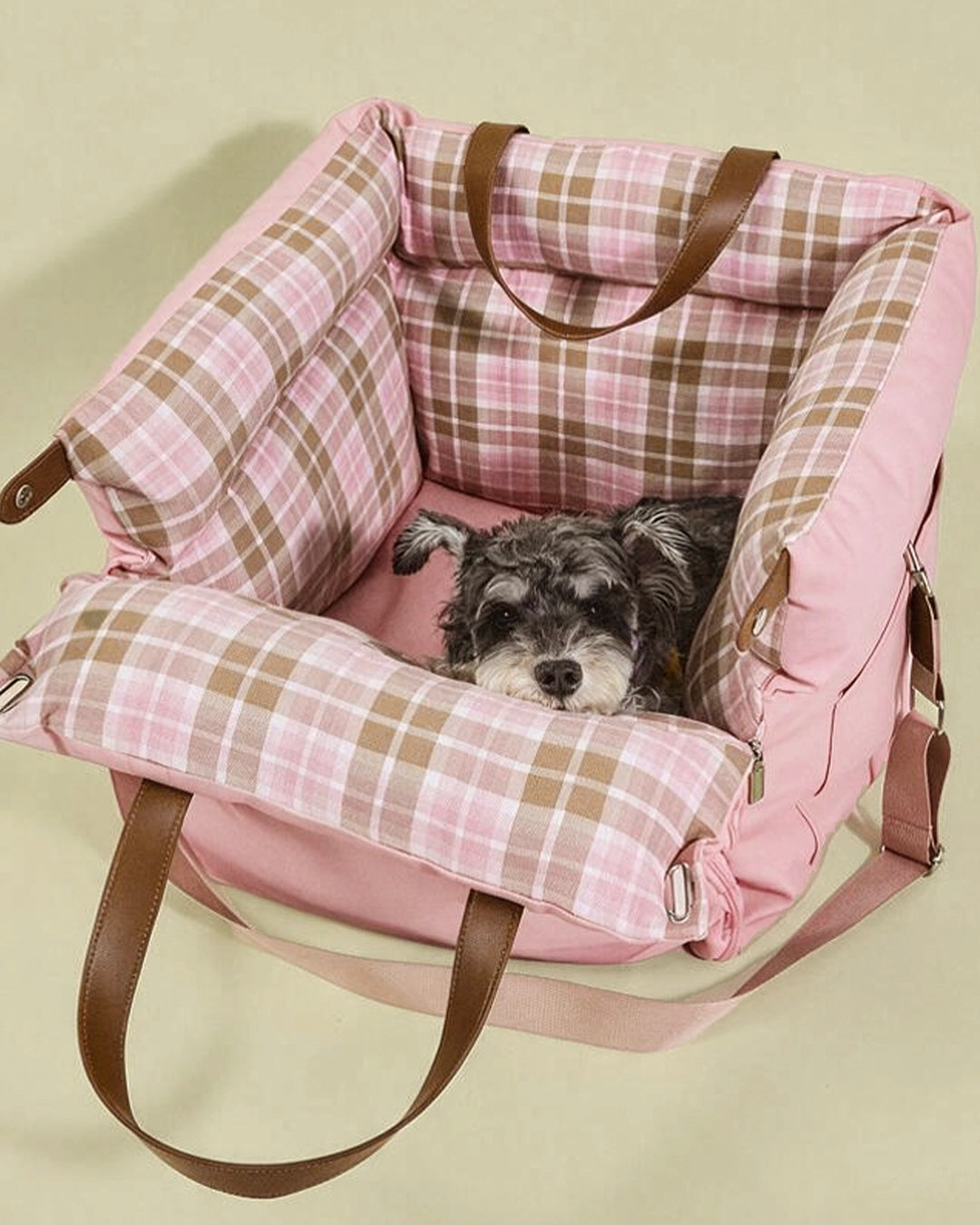 Cozy pink plaid dog car seat with plush supportive padding, creating a calming travel nest that fits puppies and small cats.