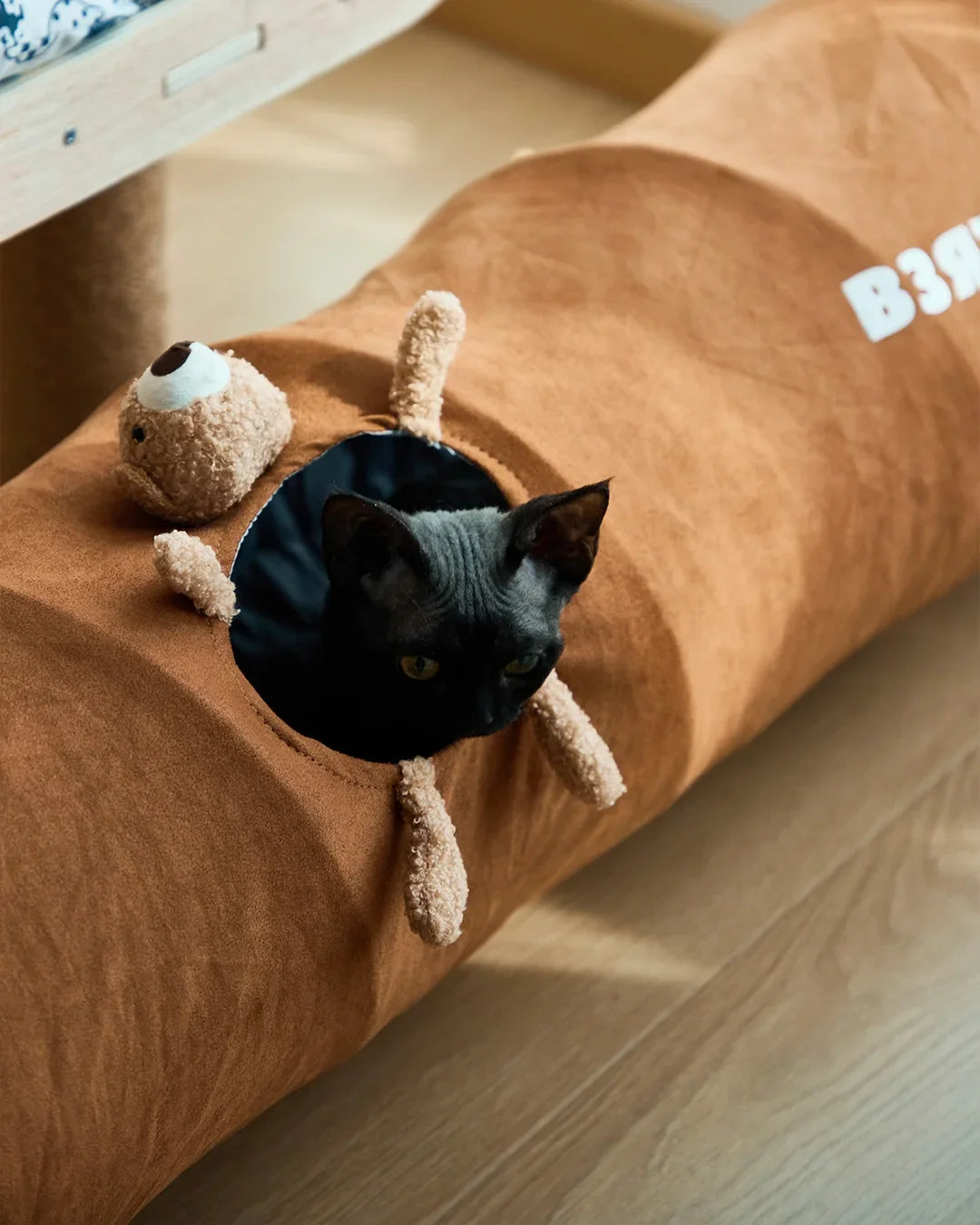 Indoor cat crawling through CharPaw plush tunnel tube for exercise and fun