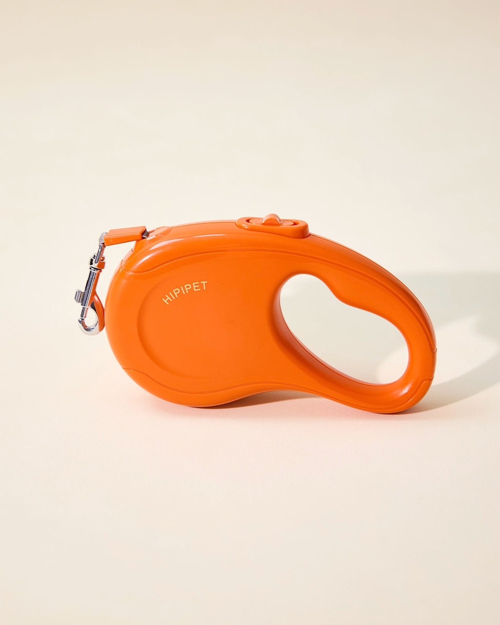Orange retractable dog leash housing with swivel hook