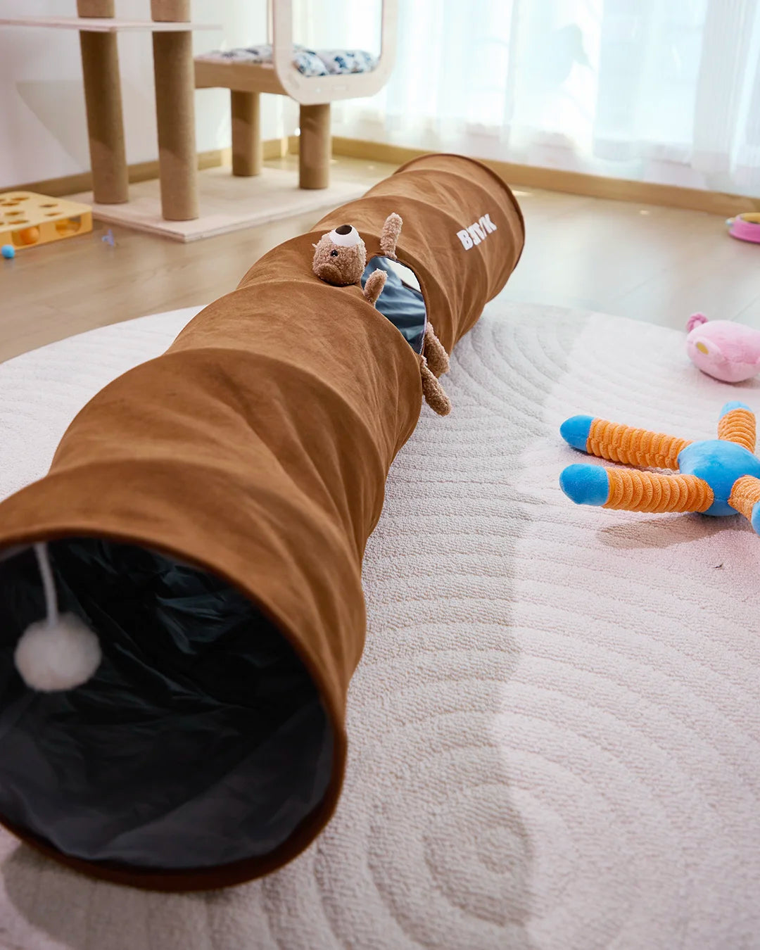 CharPaw brown plush cat tunnel with hanging toy ball on living room floor