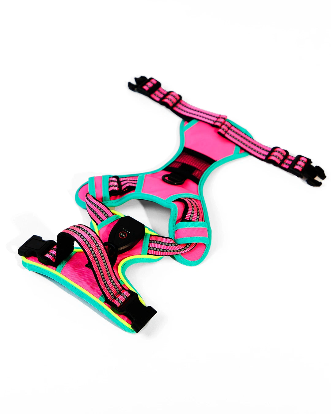 Flat lay view of rose pink and mint green rechargeable LED dog harness with quick-release buckles