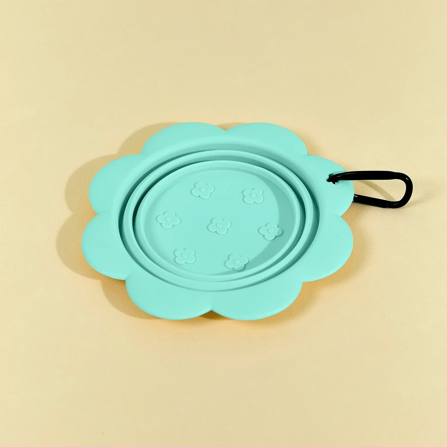 	Green collapsible flower pet bowl shown open with a carabiner clip attached