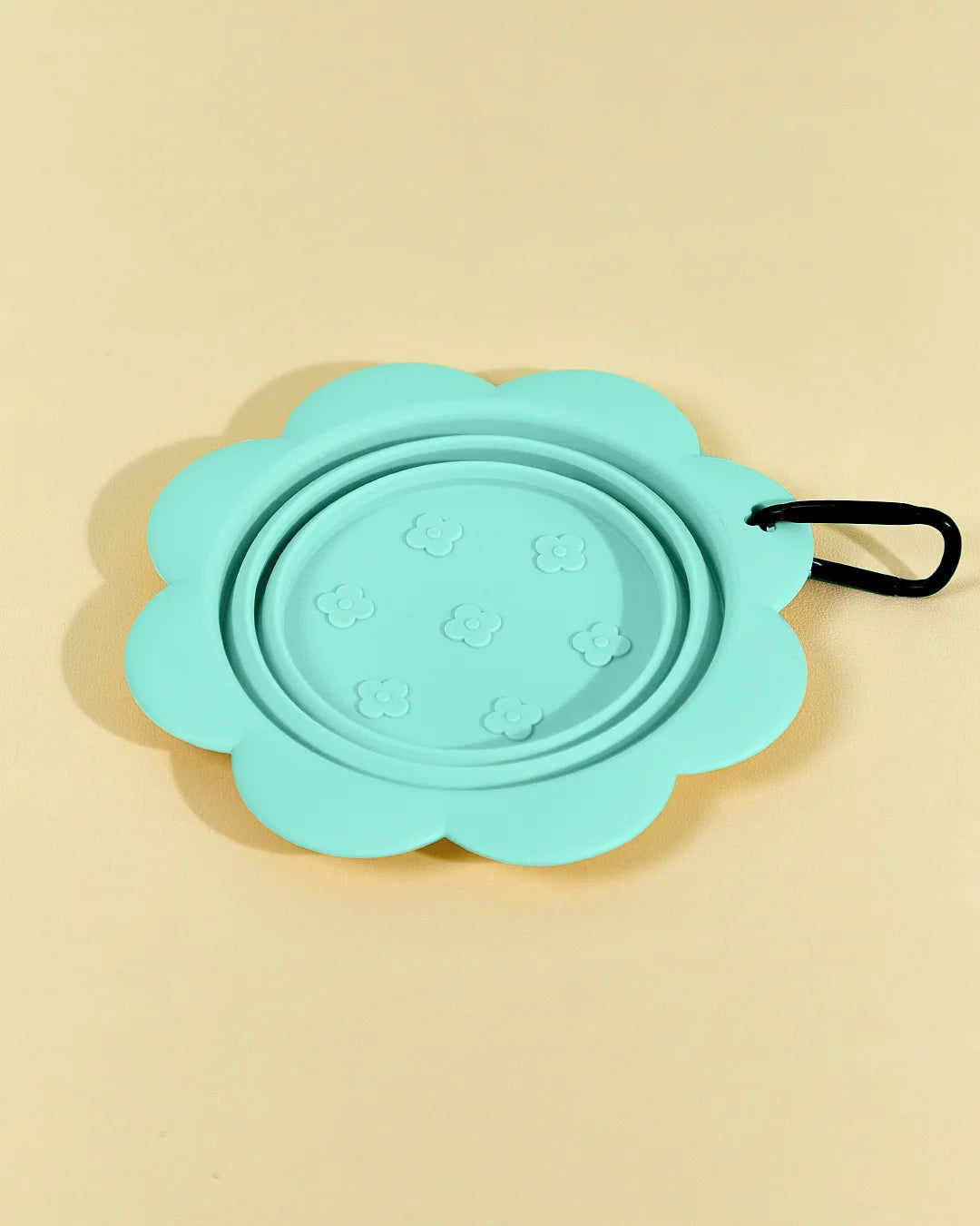 	Green collapsible flower pet bowl shown open with a carabiner clip attached