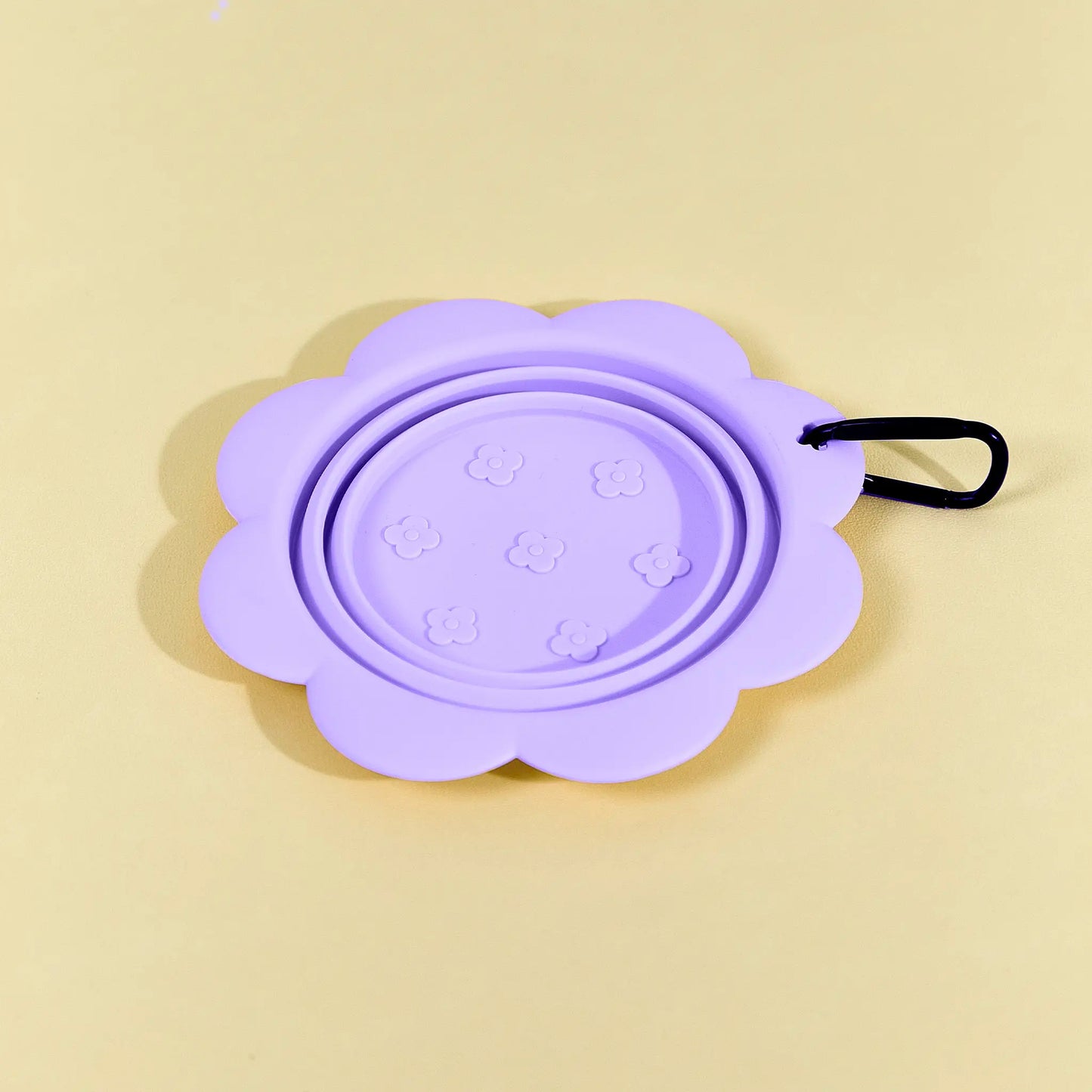 Purple collapsible flower pet bowl shown open with a carabiner clip attached