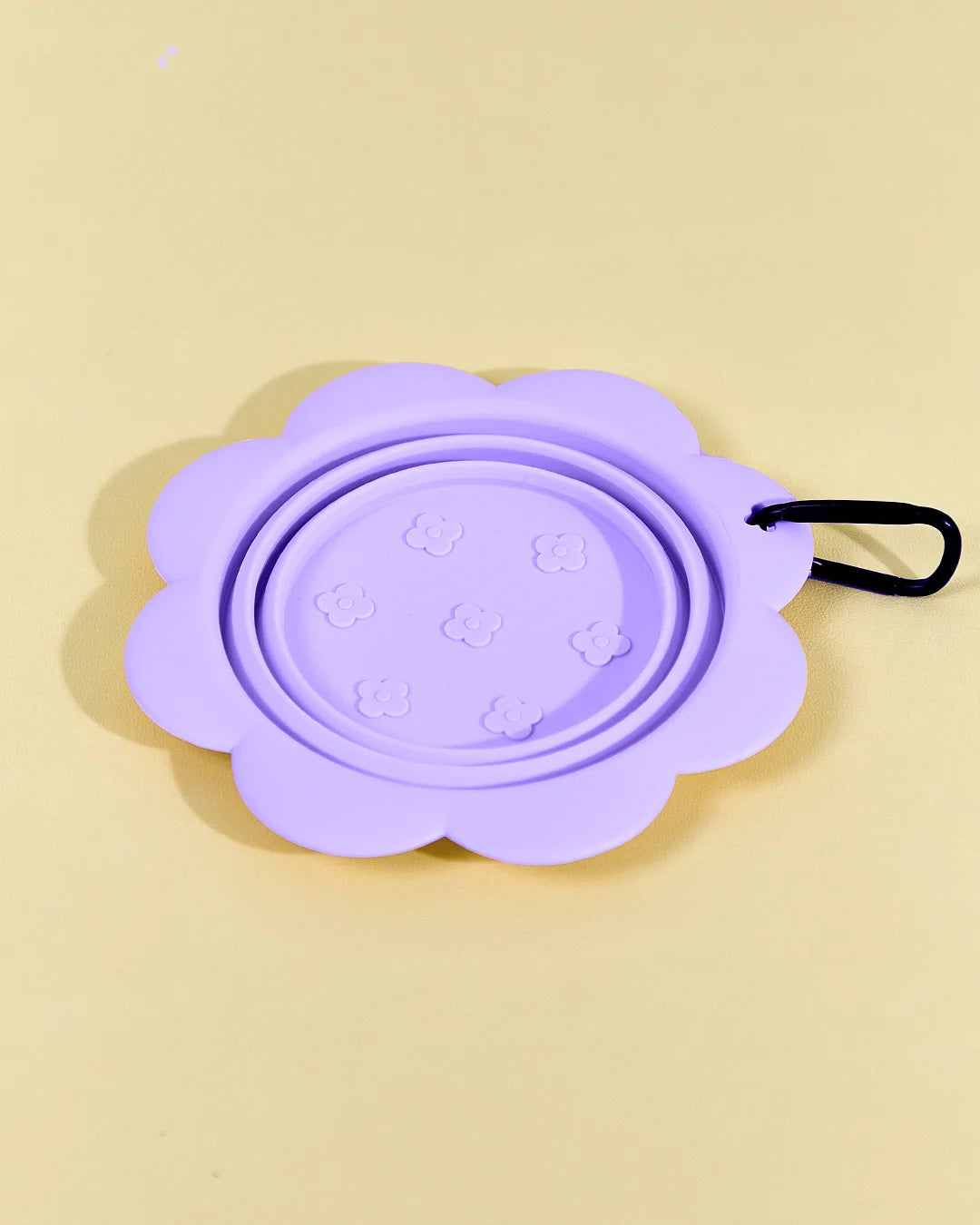 Purple collapsible flower pet bowl shown open with a carabiner clip attached