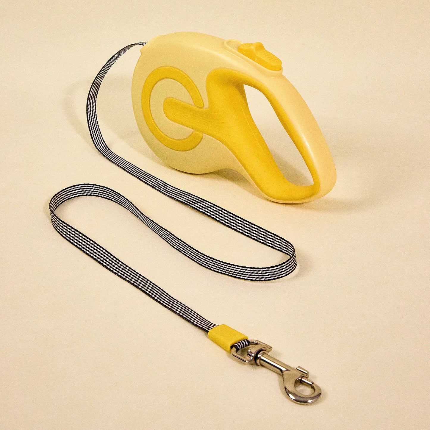 Yellow retractable dog leash with the nylon cord fully extended, shown on a plain background