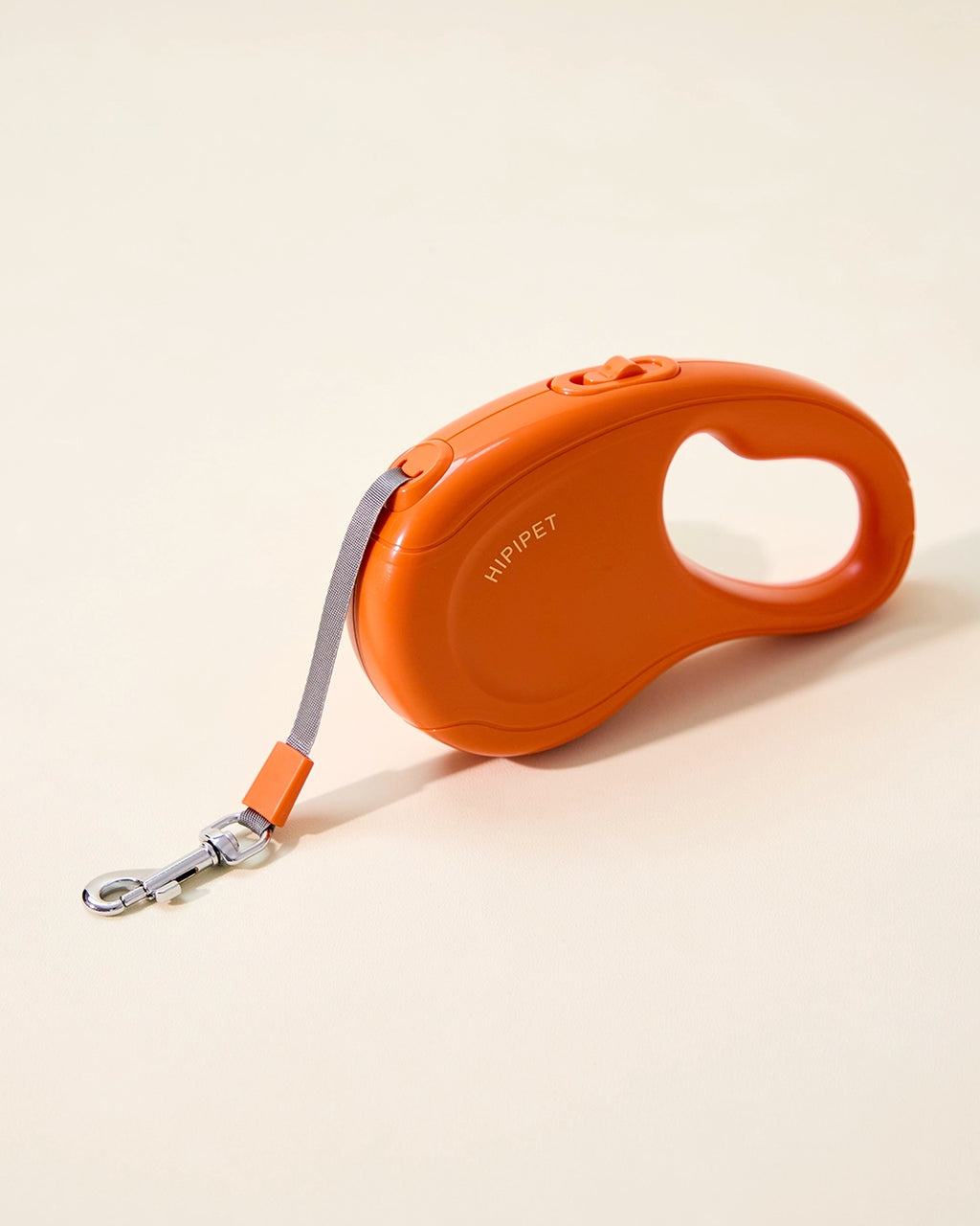Orange retractable dog leash with ergonomic handle layout