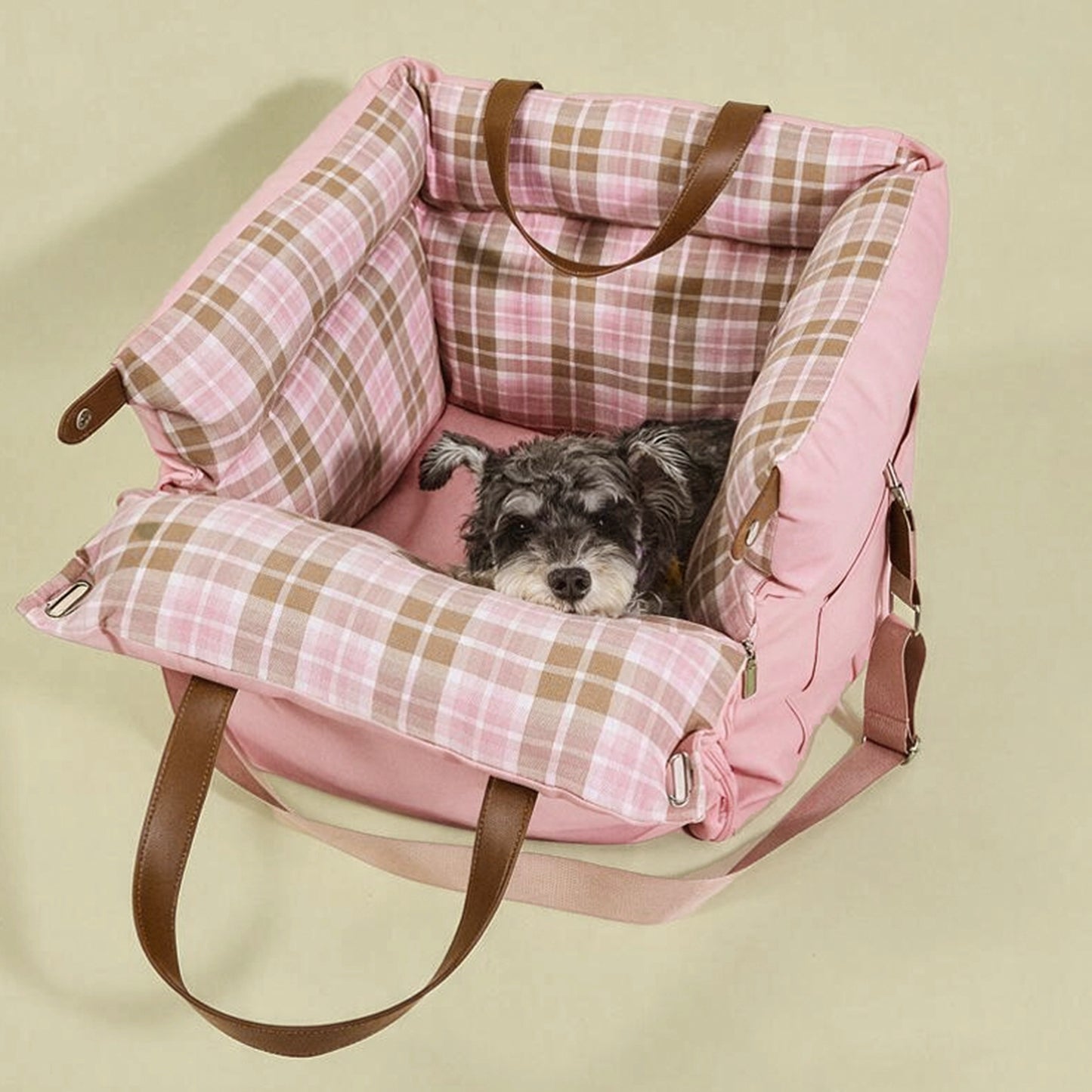 Cozy pink plaid dog car seat with plush supportive padding, creating a calming travel nest that fits puppies and small cats.