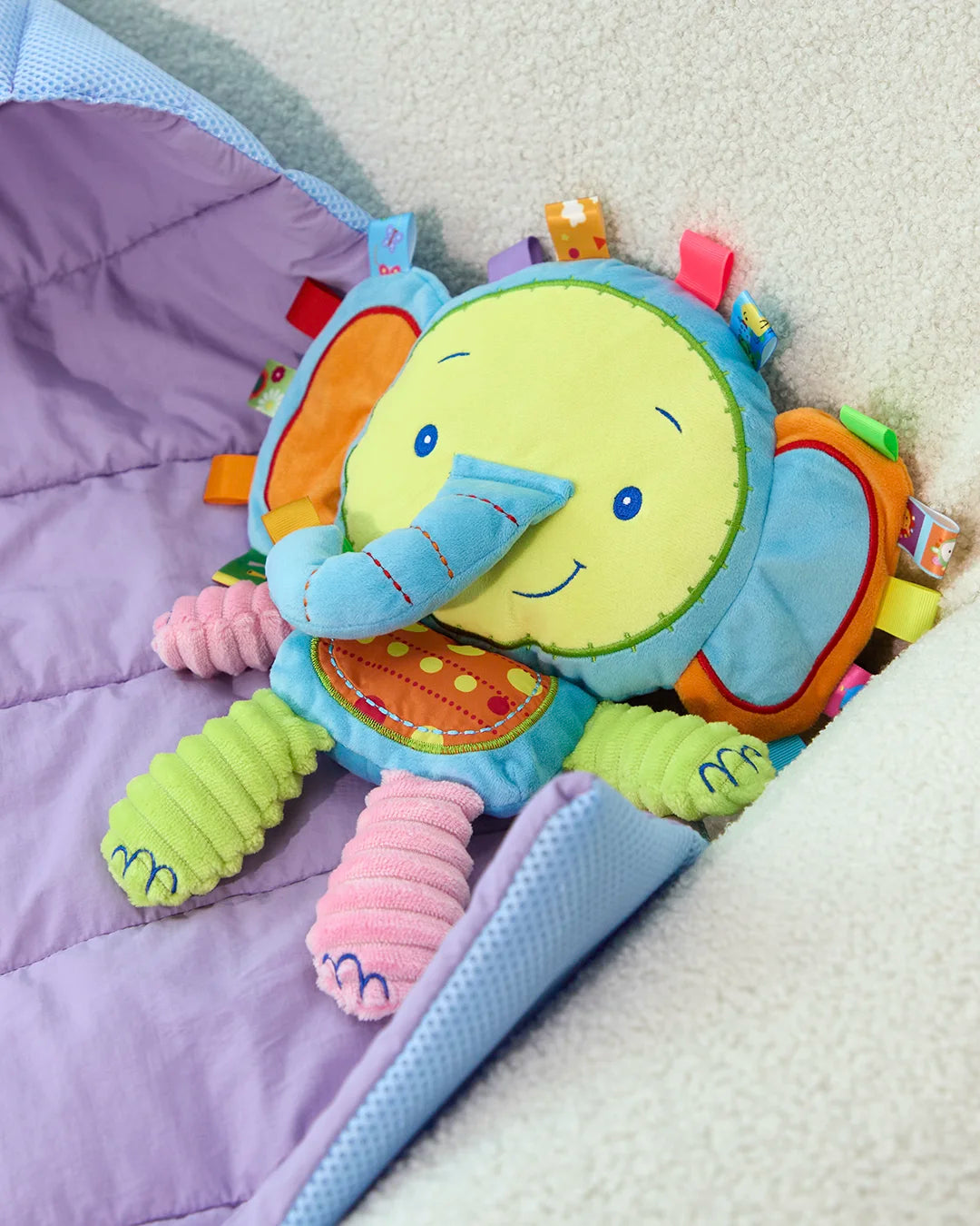 Soft blue elephant crinkle dog toy folded on a blanket